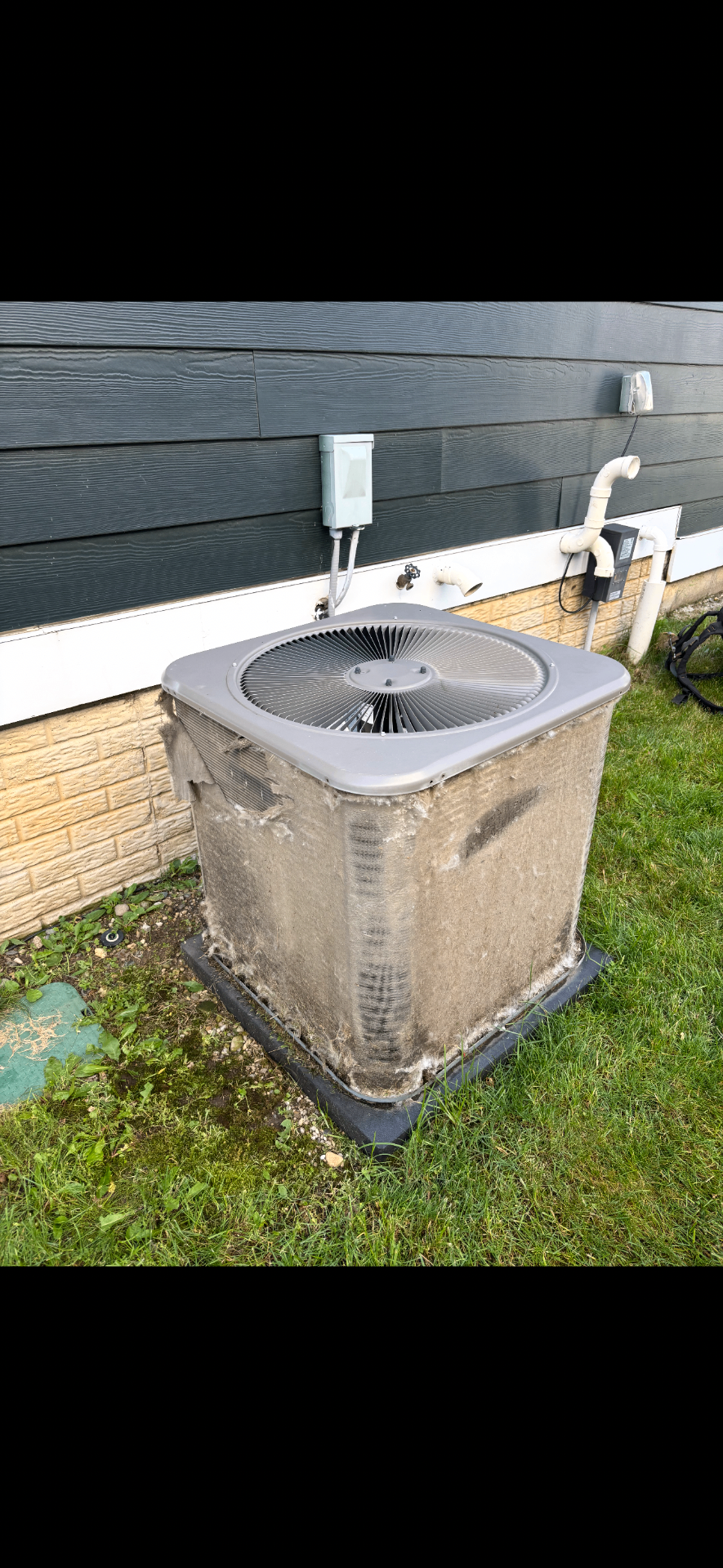 Before: outdoor condenser caked in cottonwood and debris restricting airflow